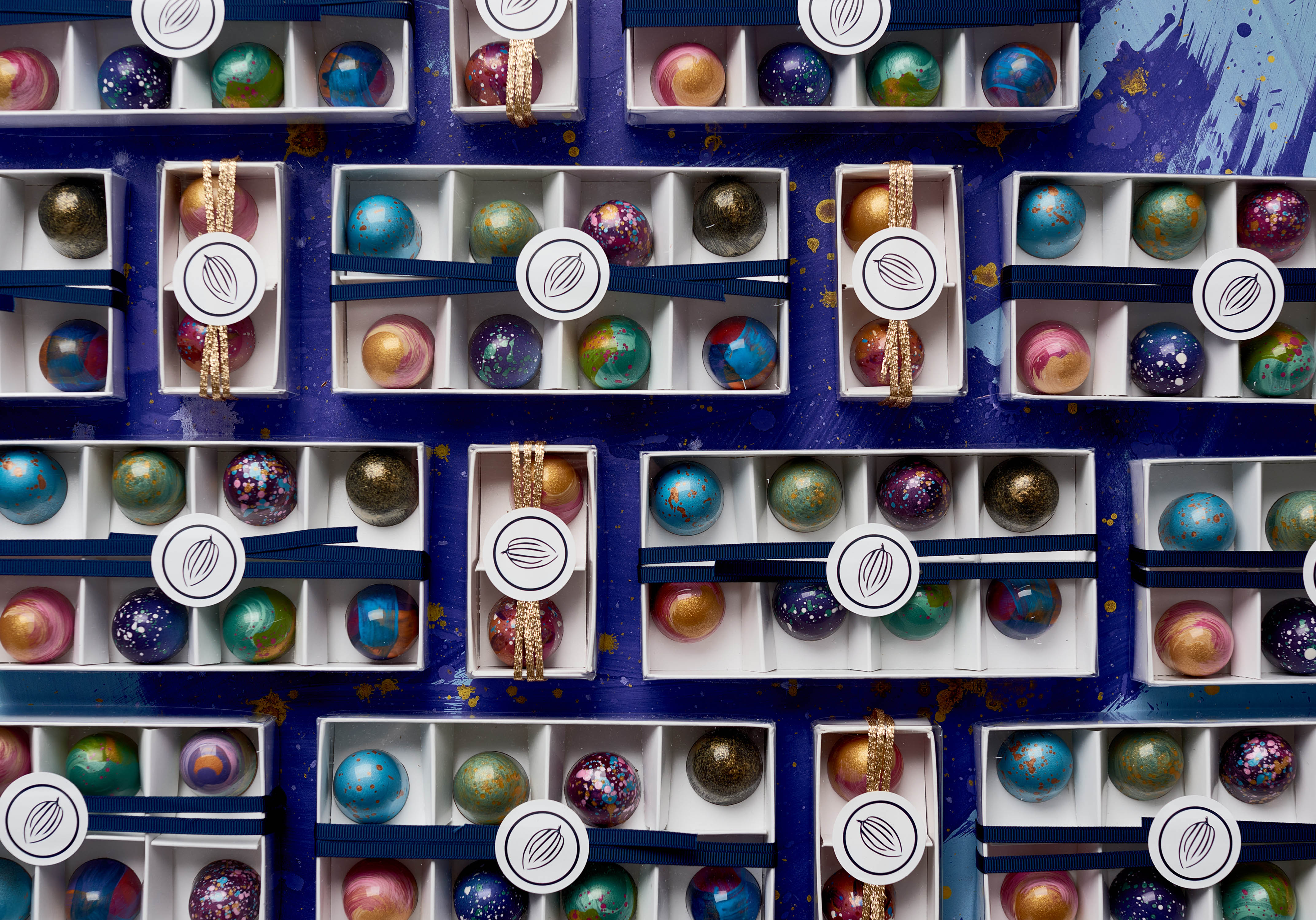 Assorted Cocoa Nib bonbons in ribboned gift boxes.
