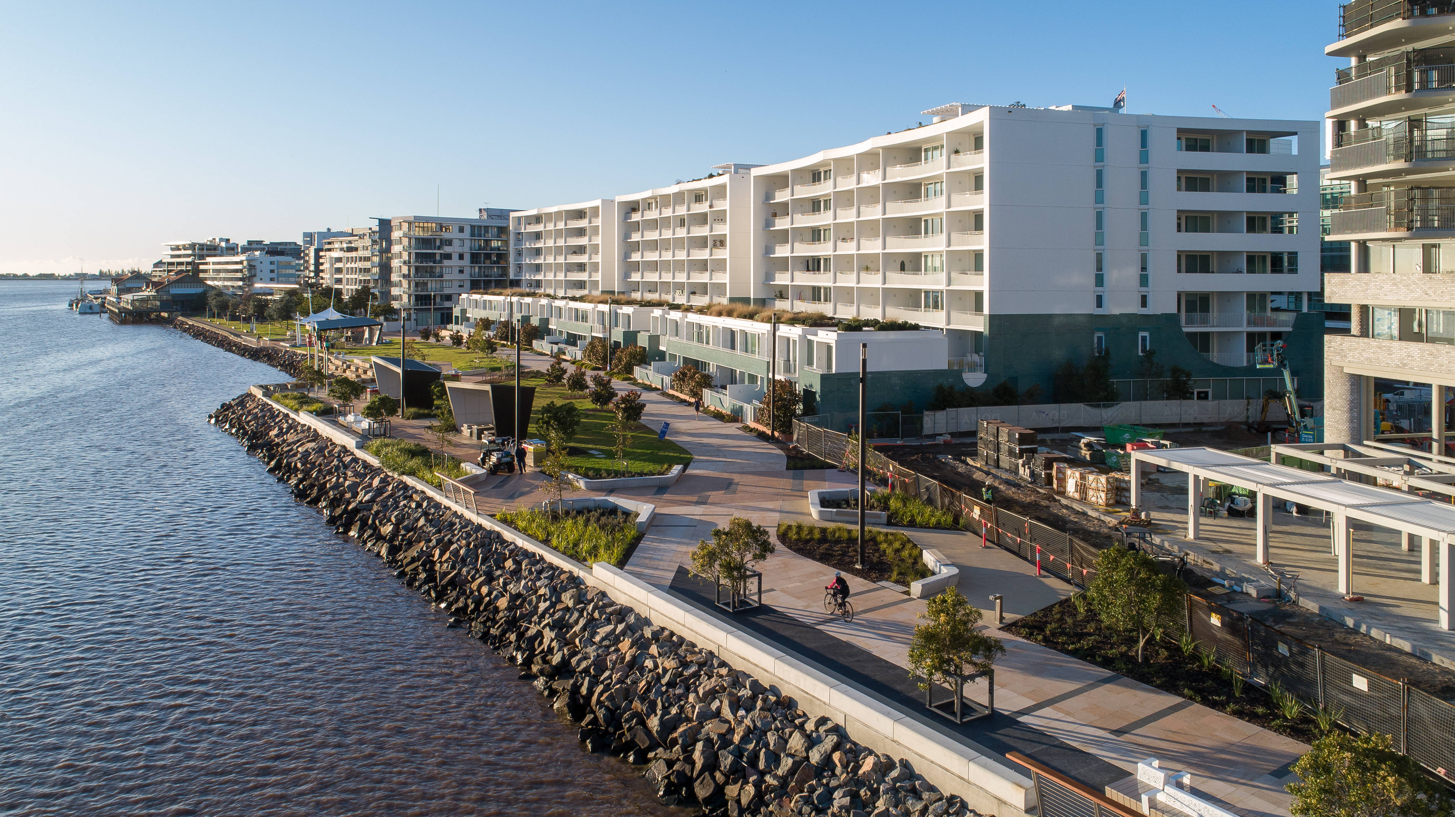 Cottage Creek waterfront promenade with landscaping and a shared path.