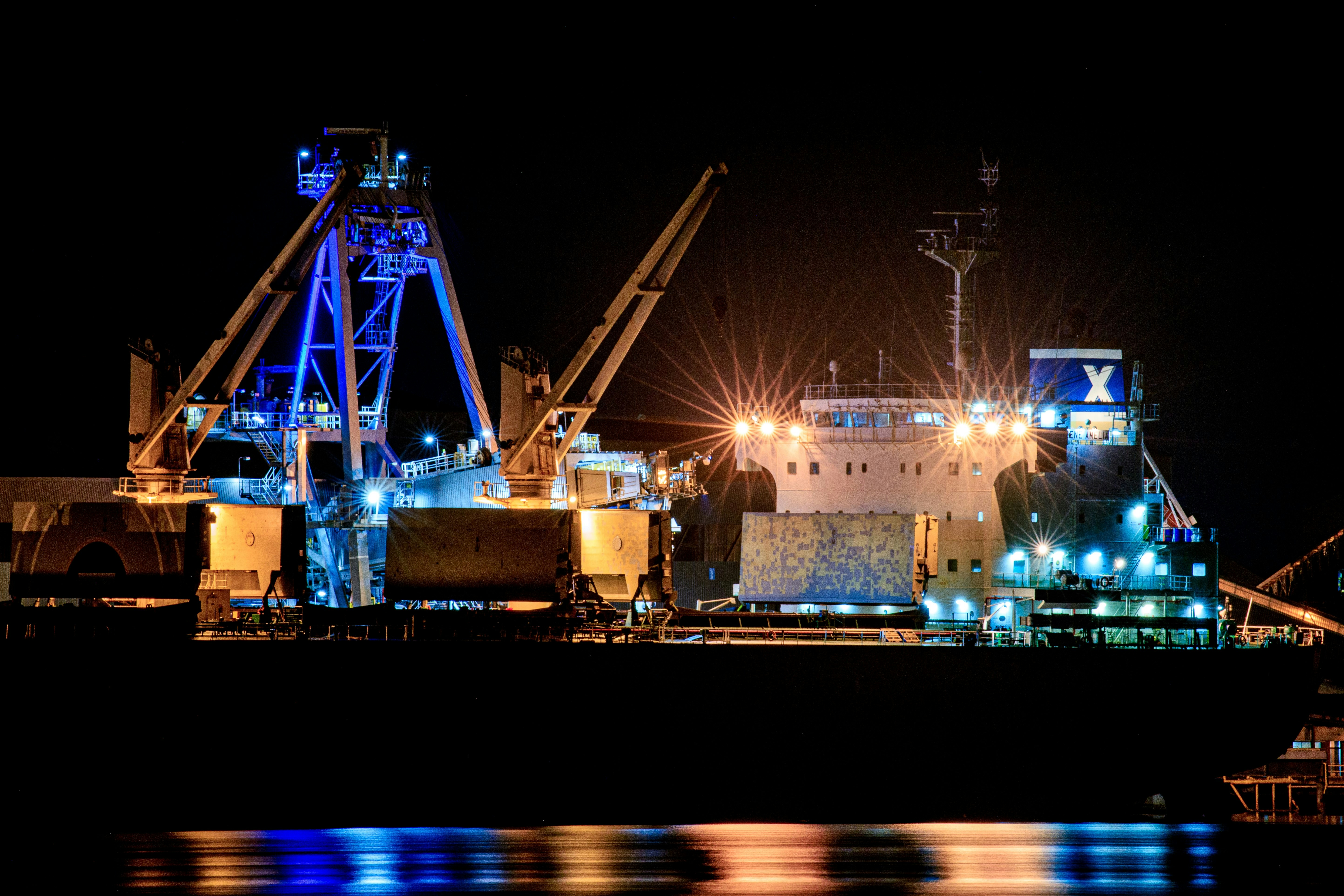 Port Waratah shiploading equipment and a vessel illuminated at night.