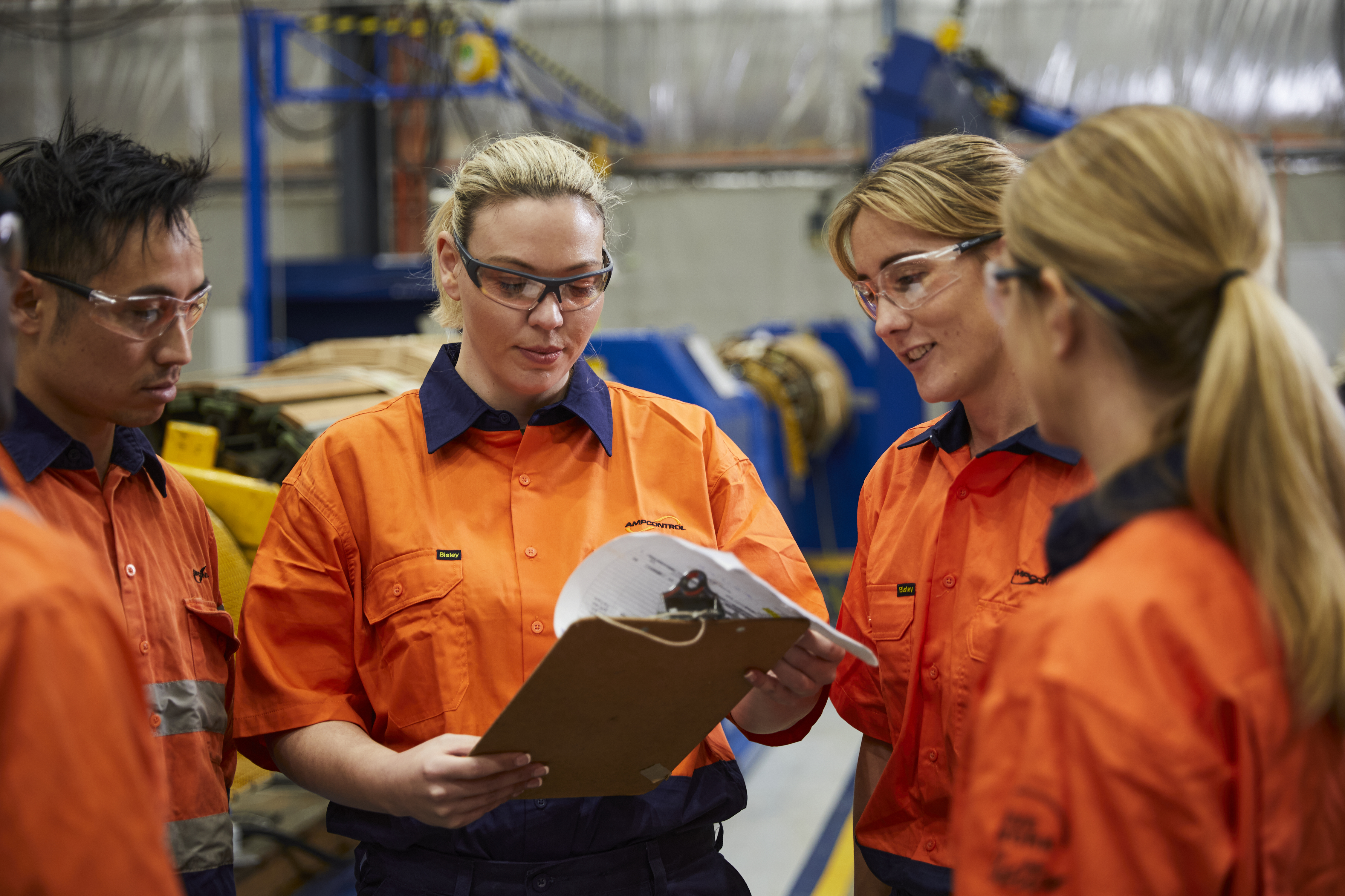 Ampcontrol employees reviewing paperwork in a workshop.