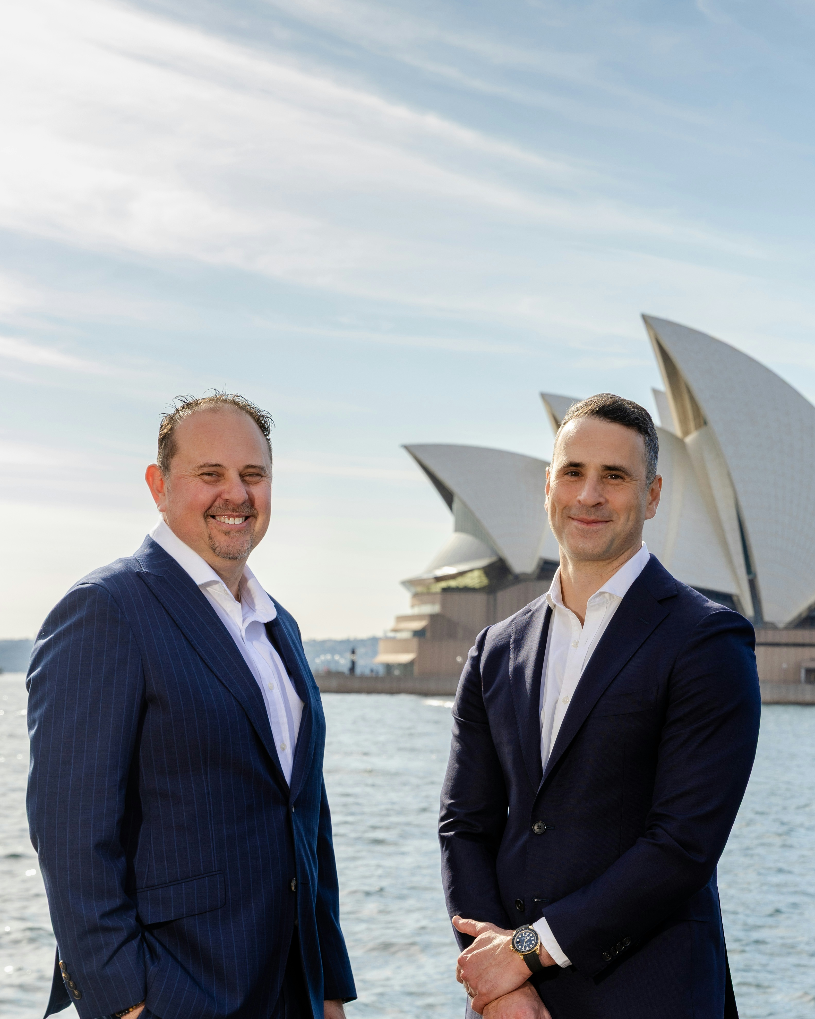 Two Aston Chace Group team members beside Sydney Harbour.